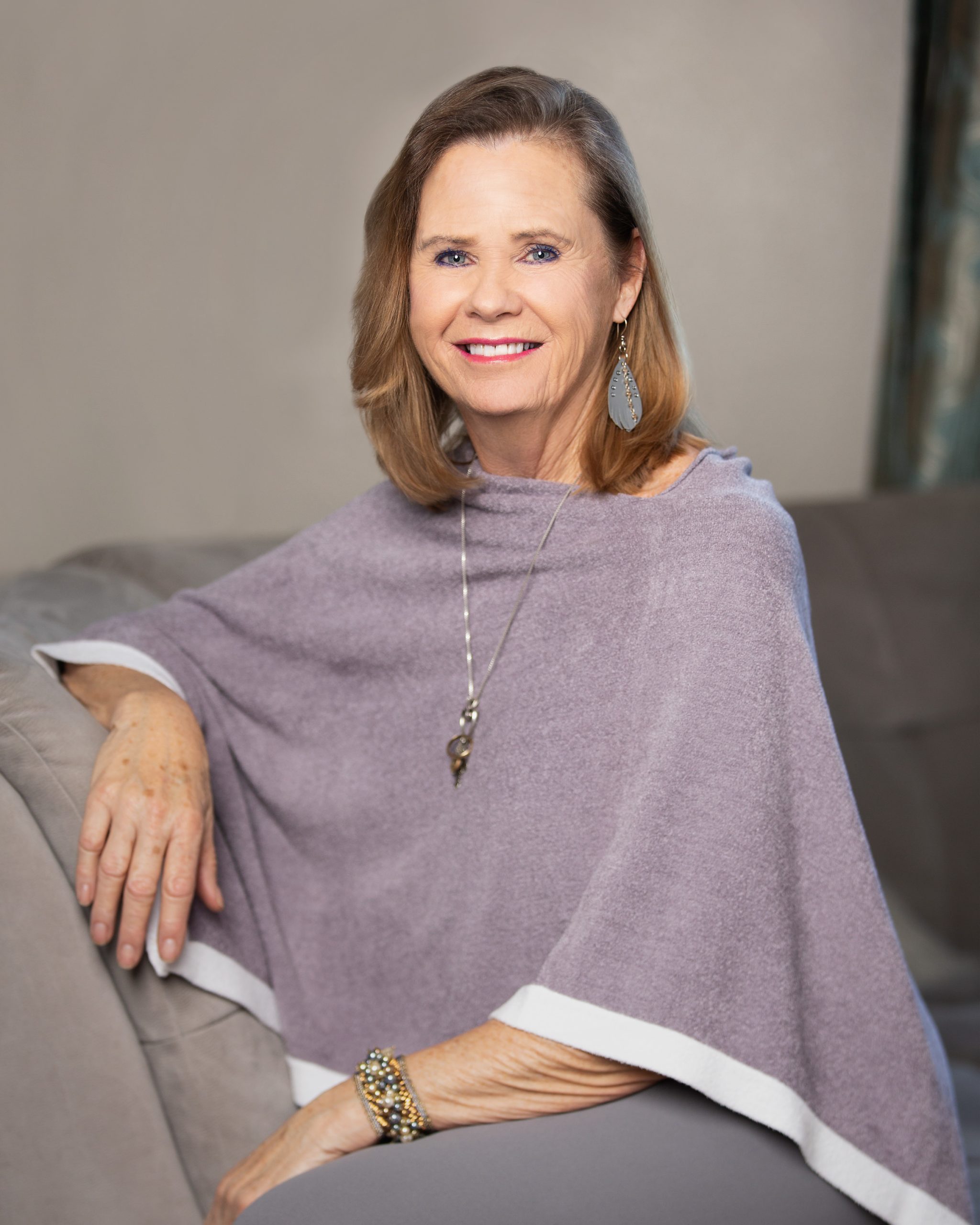 Branding headshot of woman with arm on couch