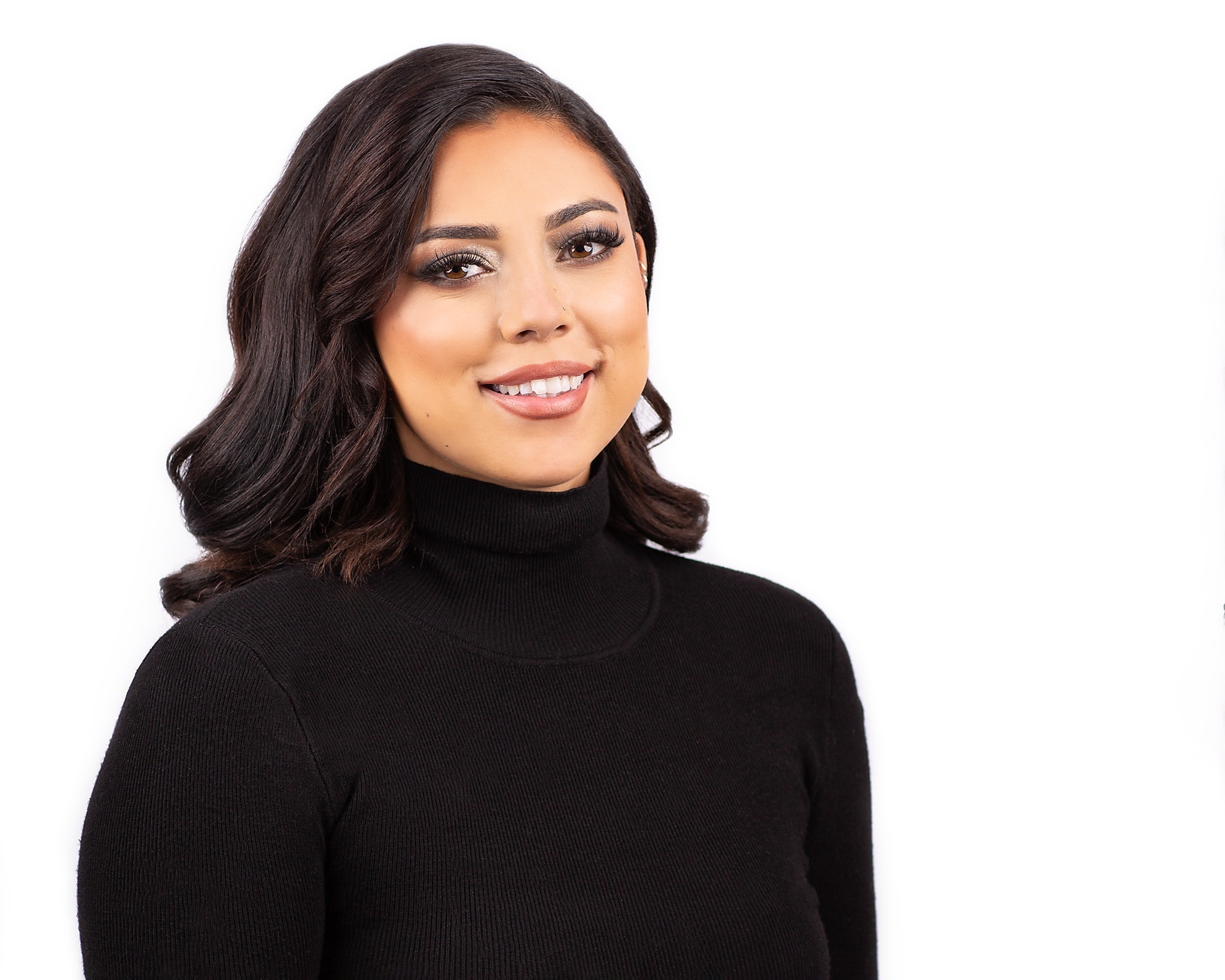 Headshot with white background of woman wearing black turtleneck